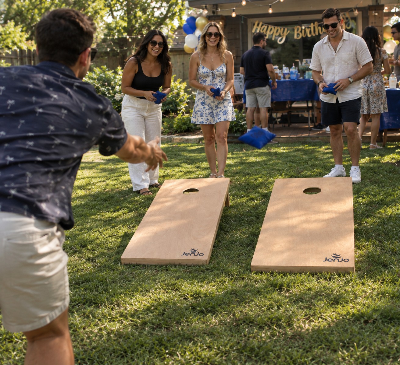 Guests playing cornhole on the lawn at a birthday party