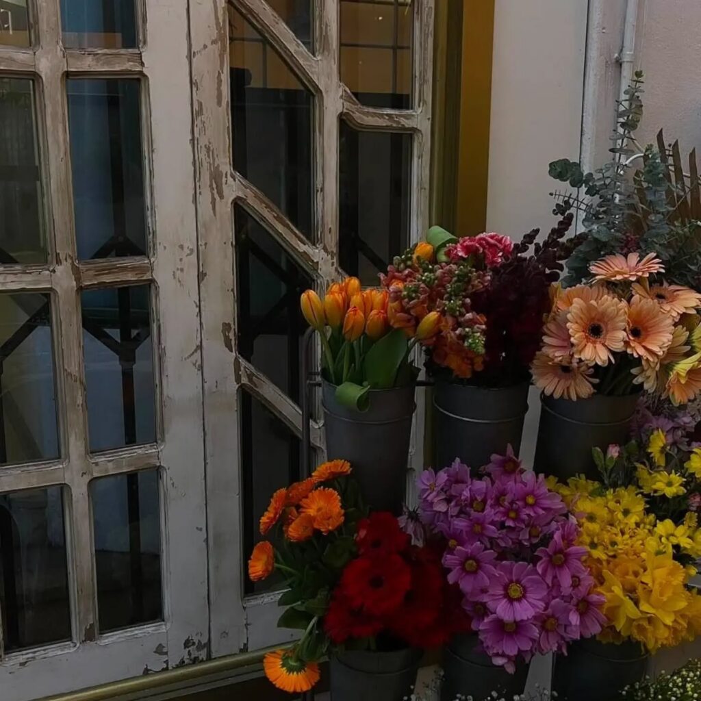 Buckets of fresh flowers beside a rustic window