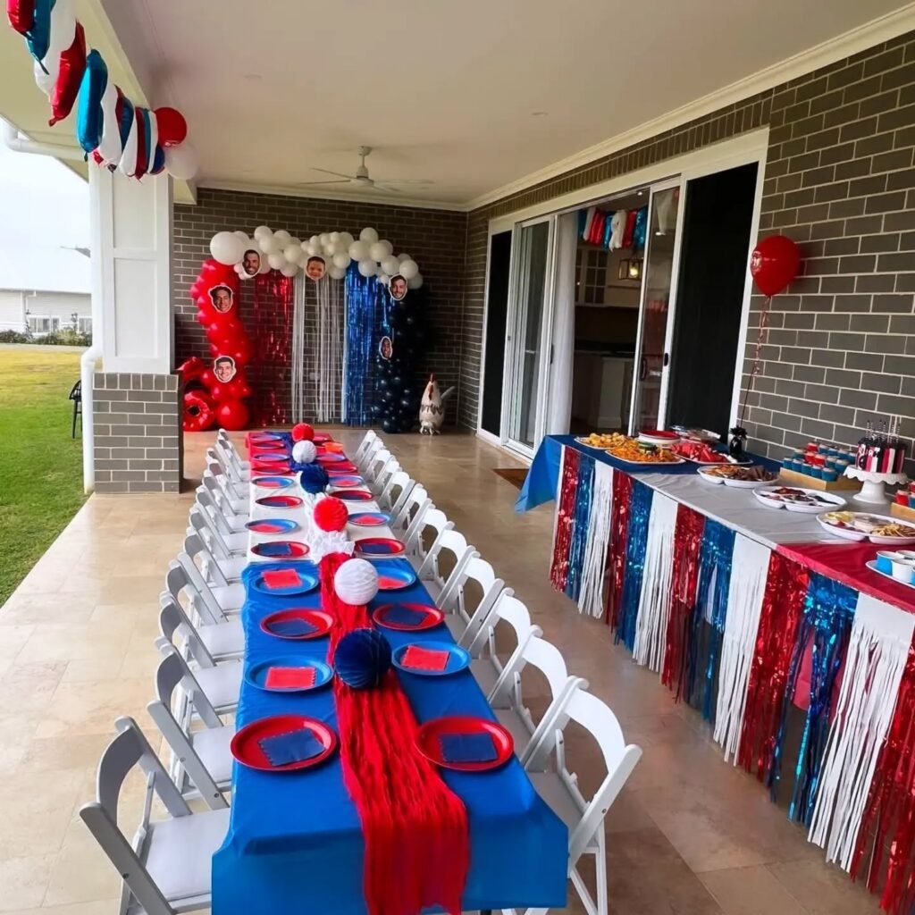 Kids party table set with red and blue decorations and white chairs
